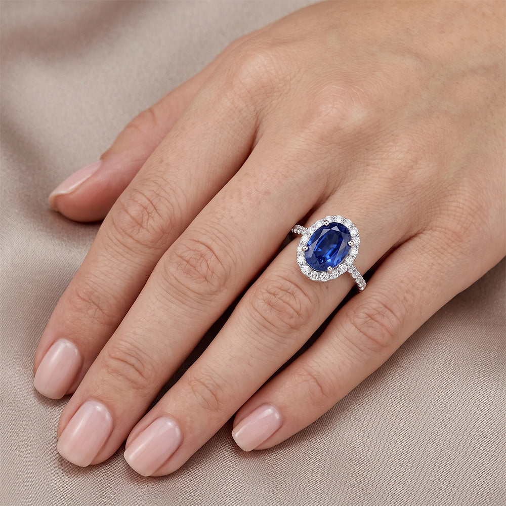 Anello Halo con diamante ovale. zaffiro blu accentato. oro bianco 5.50 carati