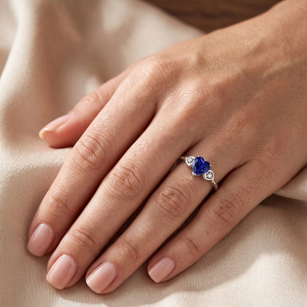 anello cuore con zaffiro blu profondo 1,75 carati e diamanti tre pietre in oro bianco 14K