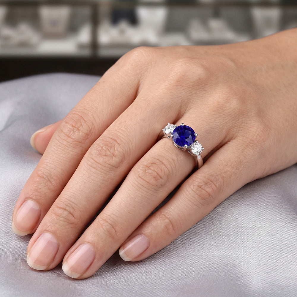 Anello di fidanzamento con tre pietre. zaffiro blu rotondo. 2.50 carati. diamanti