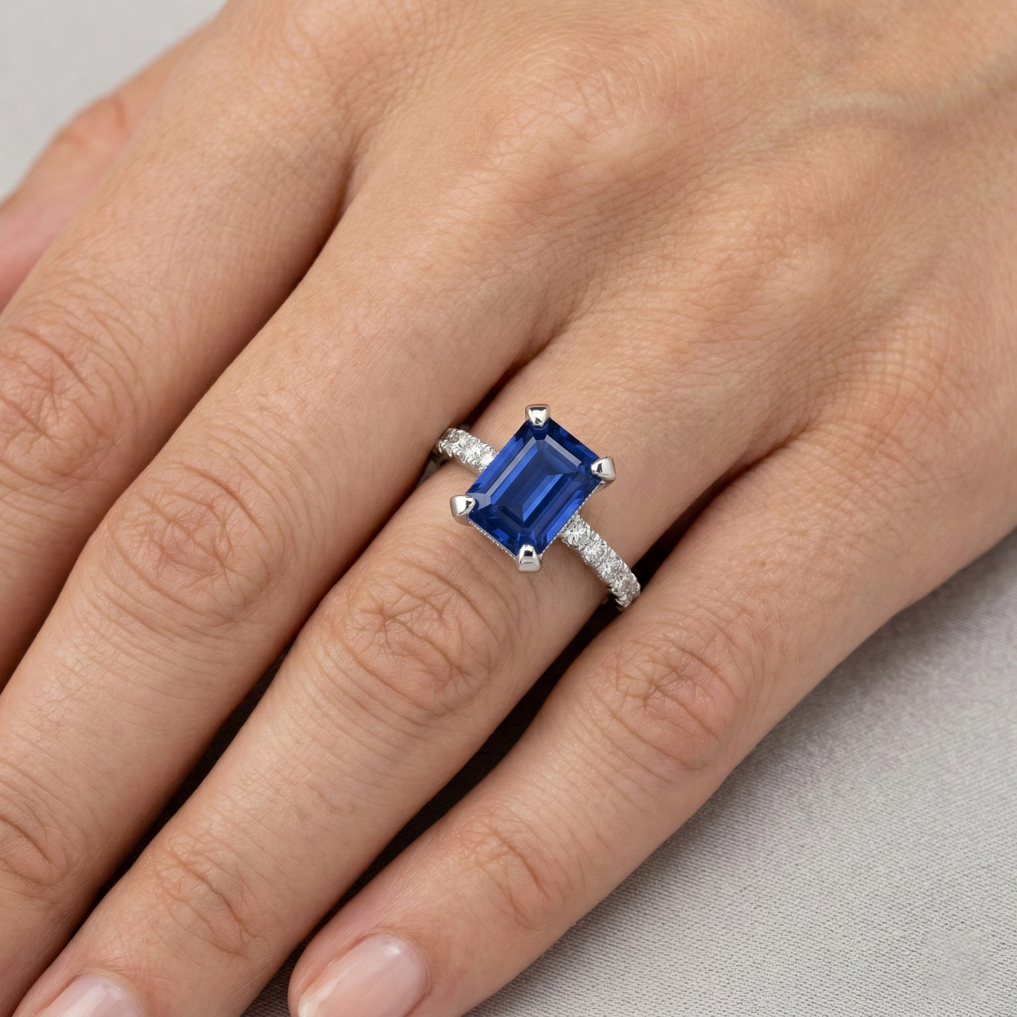 Anello con smeraldo 3 carati incastonato e zaffiro di Ceylon tondo con diamanti in oro bianco 14K